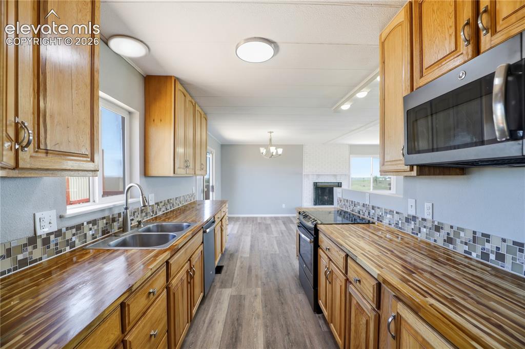 Image 10 of 48: Butcher Block, Open Concept, Vinyl Plank, Mud Space Through Kitchen, Dining