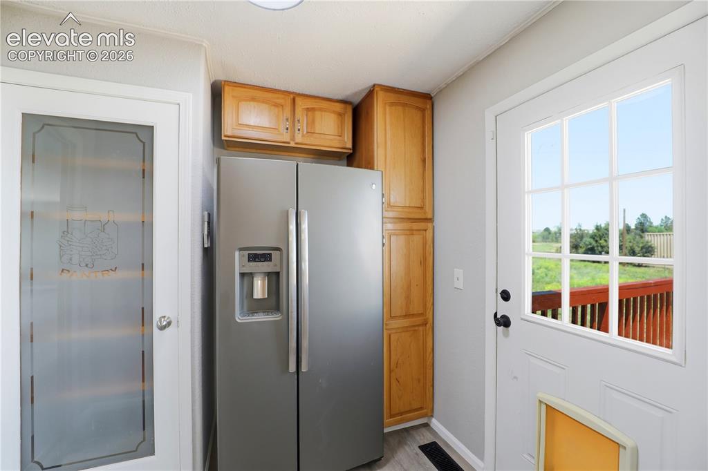 Image 12 of 48: Mud Space, Pantry, Fridge, Extra Cabinets