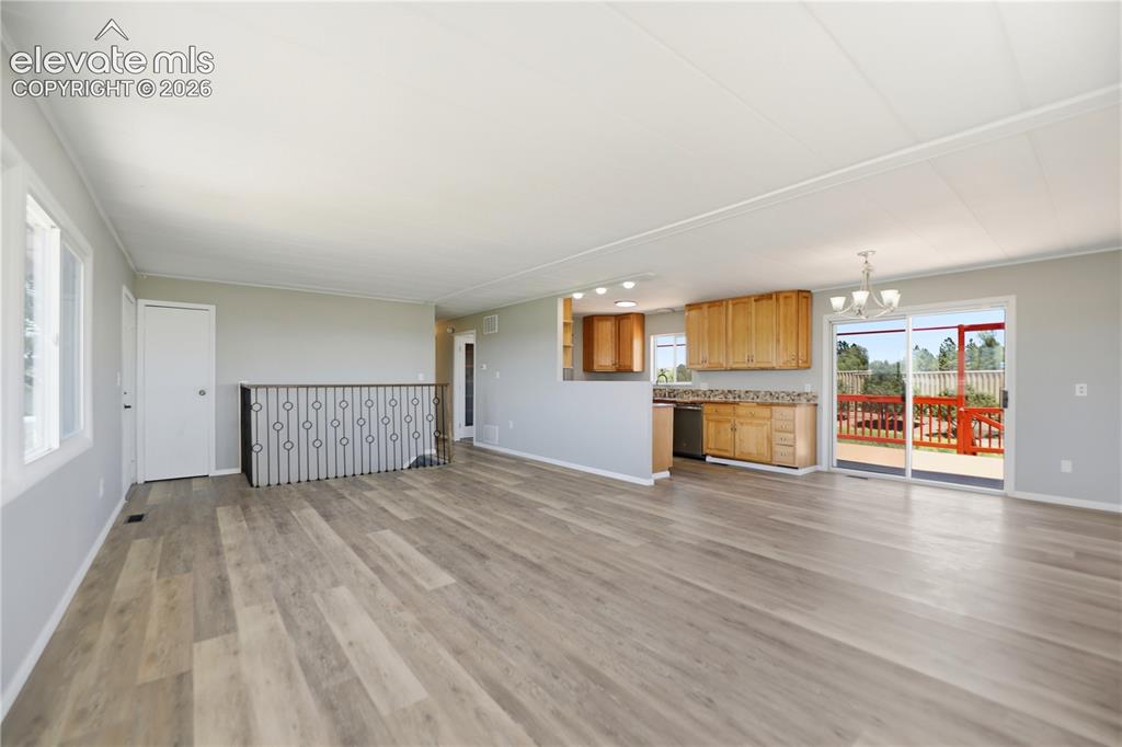 Image 3 of 48: Vinyl Plank, Fireplace, Open Concept Living Room, Dining Kitchen, Stairs