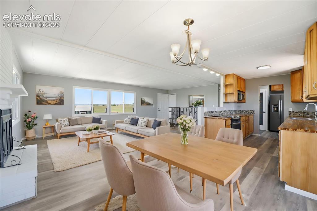 Image 6 of 48: Vinyl Plank, Fireplace, Sliding Door To Deck, Dining Area