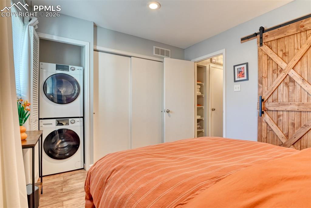 Image 15 of 20: Stacked Laundry Units tucked away in Primary Bedroom