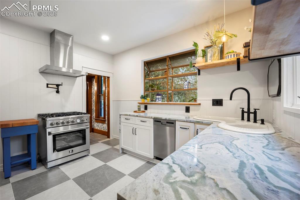 Image 10 of 48: Kitchen with open shelves, appliances with stainless steel finishes, light 