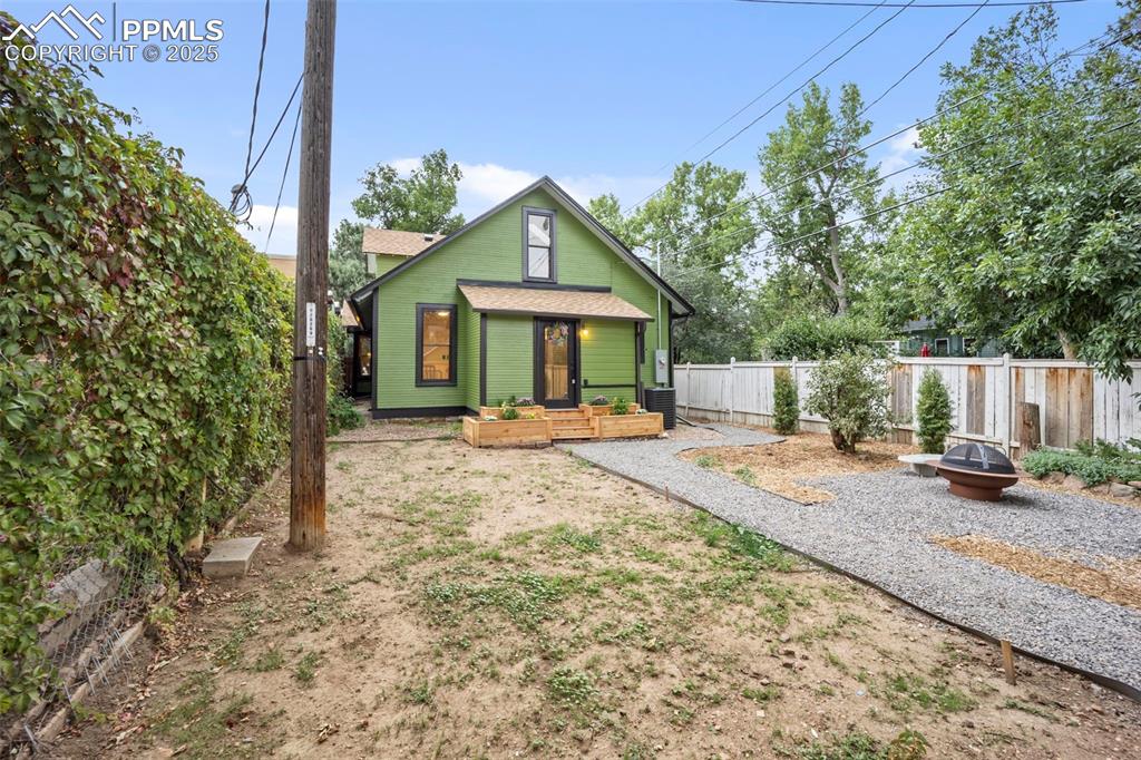 Image 38 of 48: Rear view of house featuring an outdoor fire pit and roof with shingles