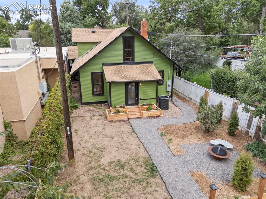 Image 45 of 48: View of front facade featuring a shingled roof, a chimney, a vegetable gard