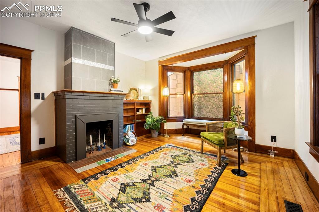 Image 5 of 48: Front room with fireplace and bay window