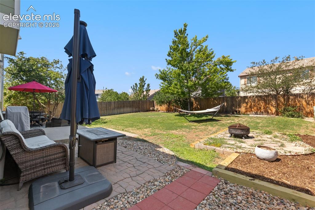 Image 19 of 39: Backyard, patio and mature trees.