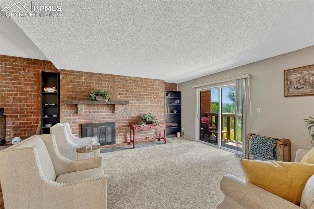 Image 15 of 48: Sunken living room with new carpet and walk out to deck overlooking the lak