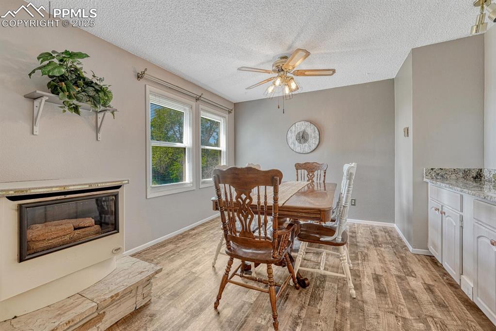 Image 19 of 48: Dining room with gas stove and ceiling fan and LVP flooring