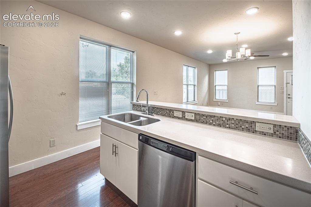 Image 16 of 50: Kitchen featuring a stainless steel double sink with gooseneck faucet, ligh