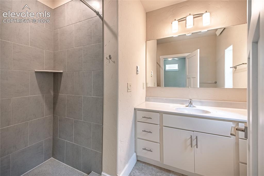 Image 20 of 50: Contemporary bathroom featuring a spacious vanity with white cabinetry, a s