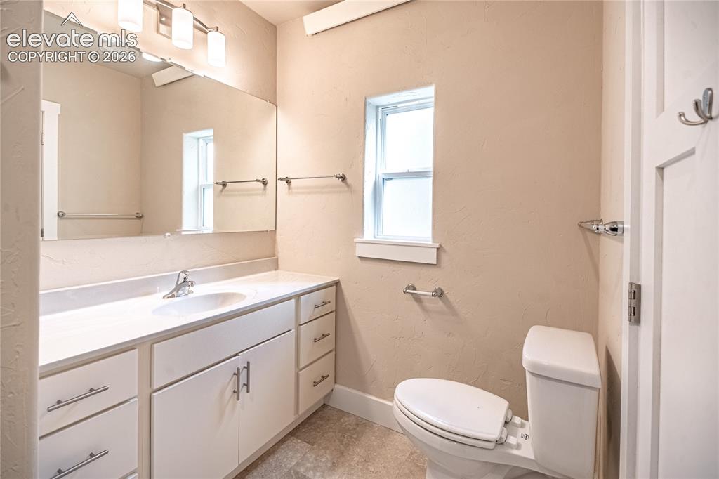 Image 21 of 50: Full-width vanity with an integrated sink, polished chrome faucet, and ampl