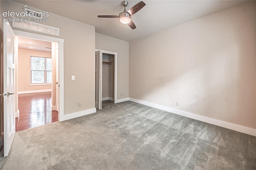Image 23 of 50: Carpeted room featuring a ceiling fan with integrated lighting, a bi-fold c