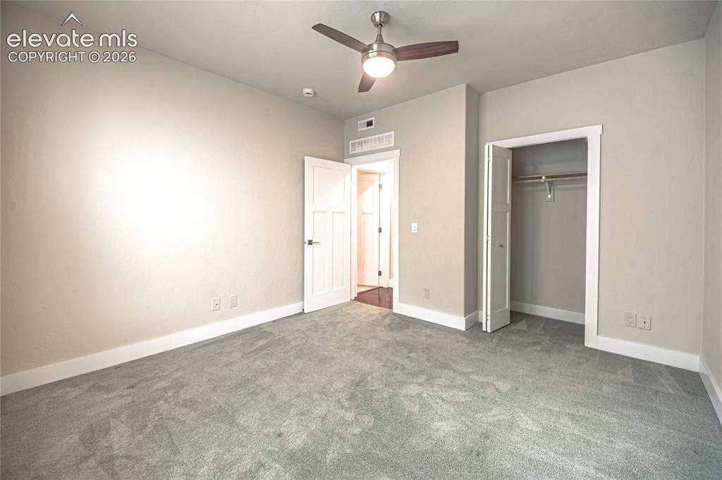 Image 24 of 50: Carpeted room featuring a ceiling fan with integrated lighting, a paneled d