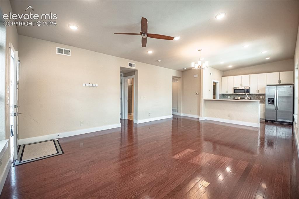 Image 26 of 50: Open-concept living space featuring wood-finish flooring, recessed lighting