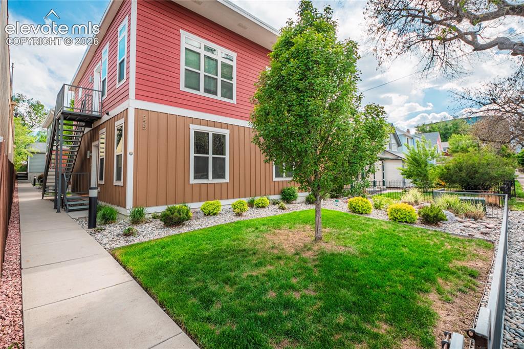 Image 3 of 50: Two-story exterior with horizontal red siding and vertical brown siding