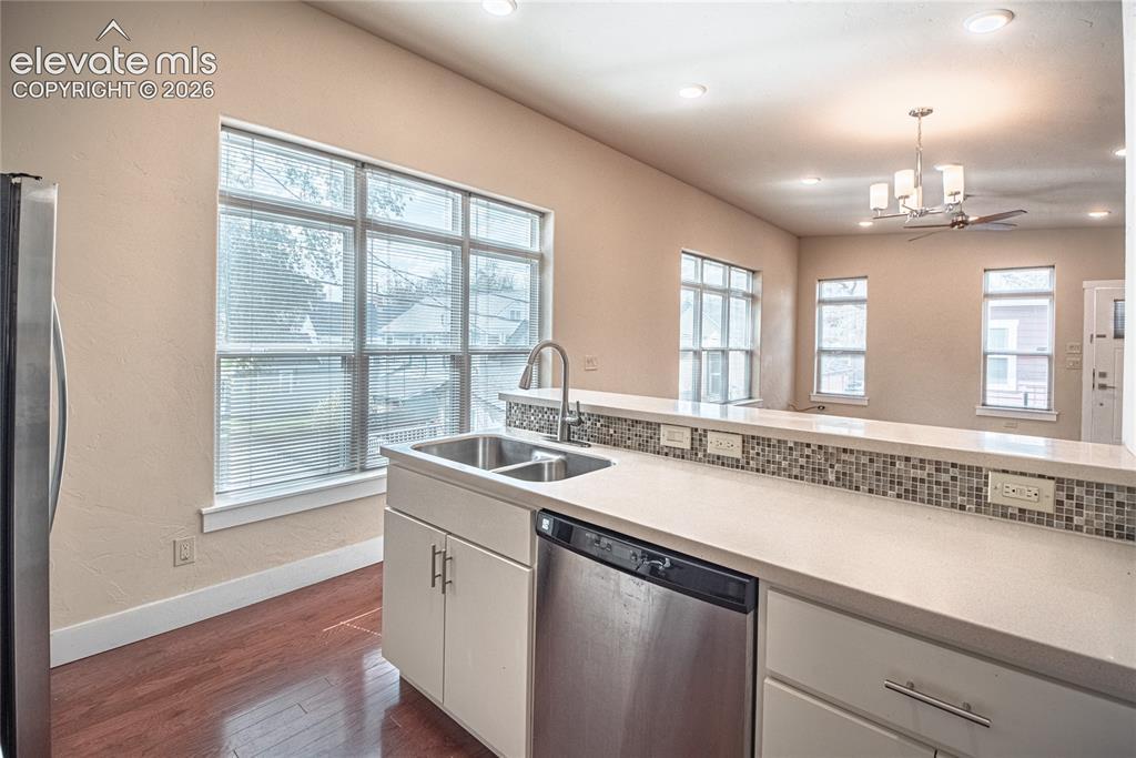 Image 31 of 50: Kitchen featuring a stainless steel double sink, a built-in dishwasher, lig