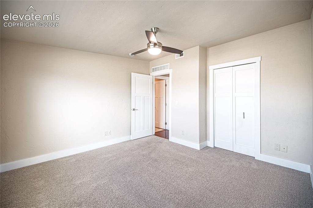 Image 40 of 50: Spacious room with neutral-toned walls, plush carpet flooring, a modern cei
