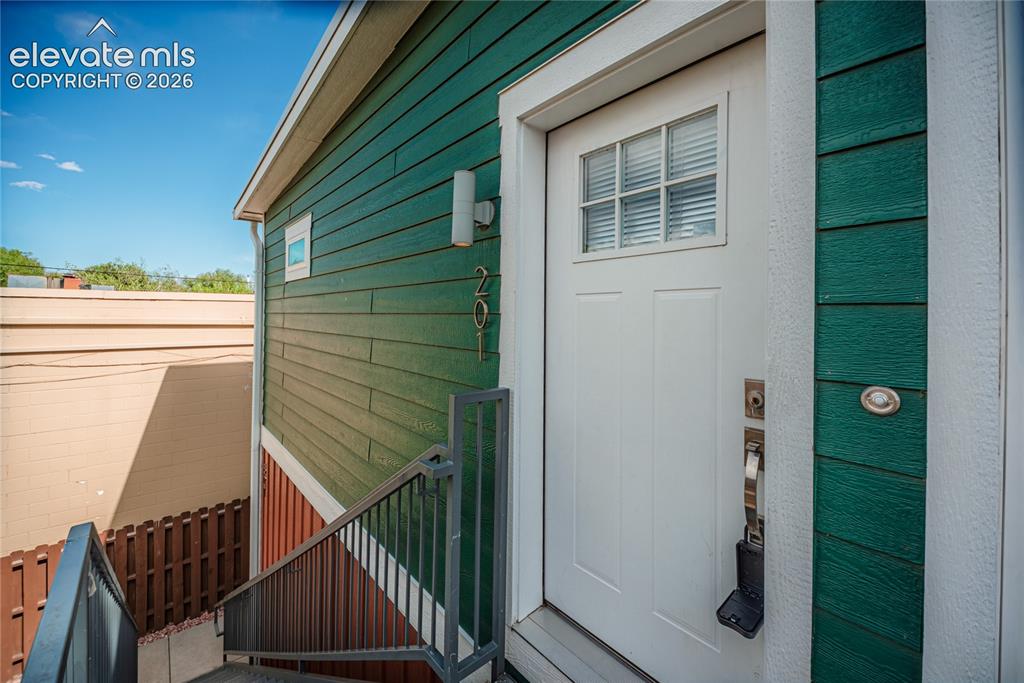 Image 45 of 50: Entryway featuring a paneled door with glass inserts, wall-mounted exterior
