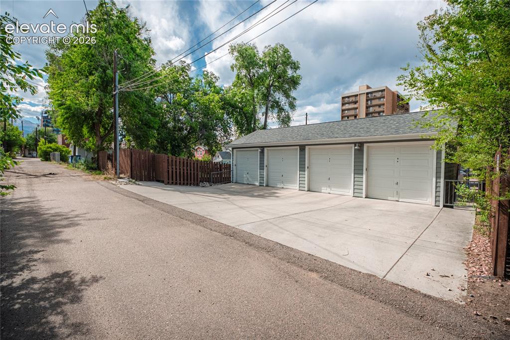 Image 8 of 50: Four individual garage bays with white panel doors