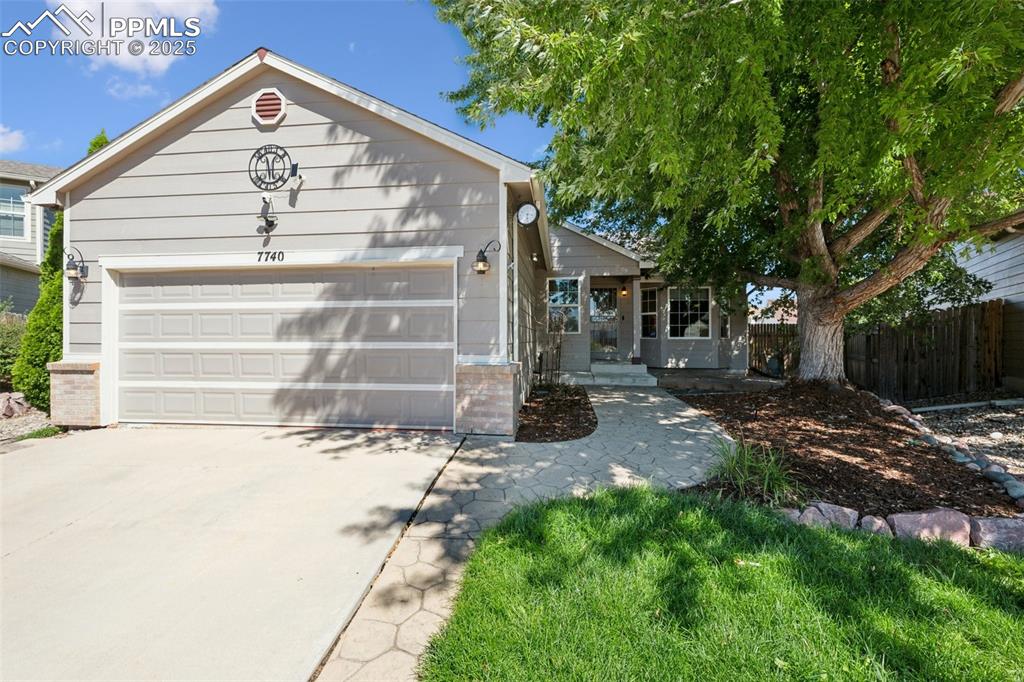 Caption: Ranch-style house featuring concrete driveway and an attached garage