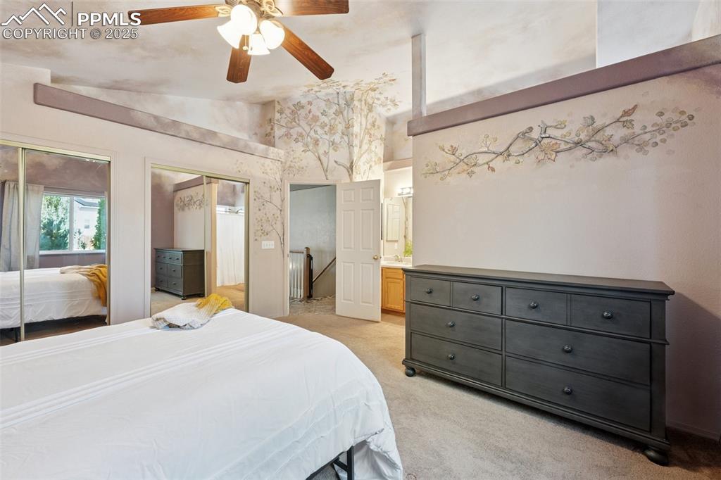 Image 10 of 27: Bedroom featuring multiple closets, light colored carpet, ensuite bathroom,