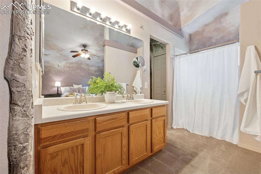 Image 11 of 27: Full bath featuring double vanity, a shower with curtain, ceiling fan, and