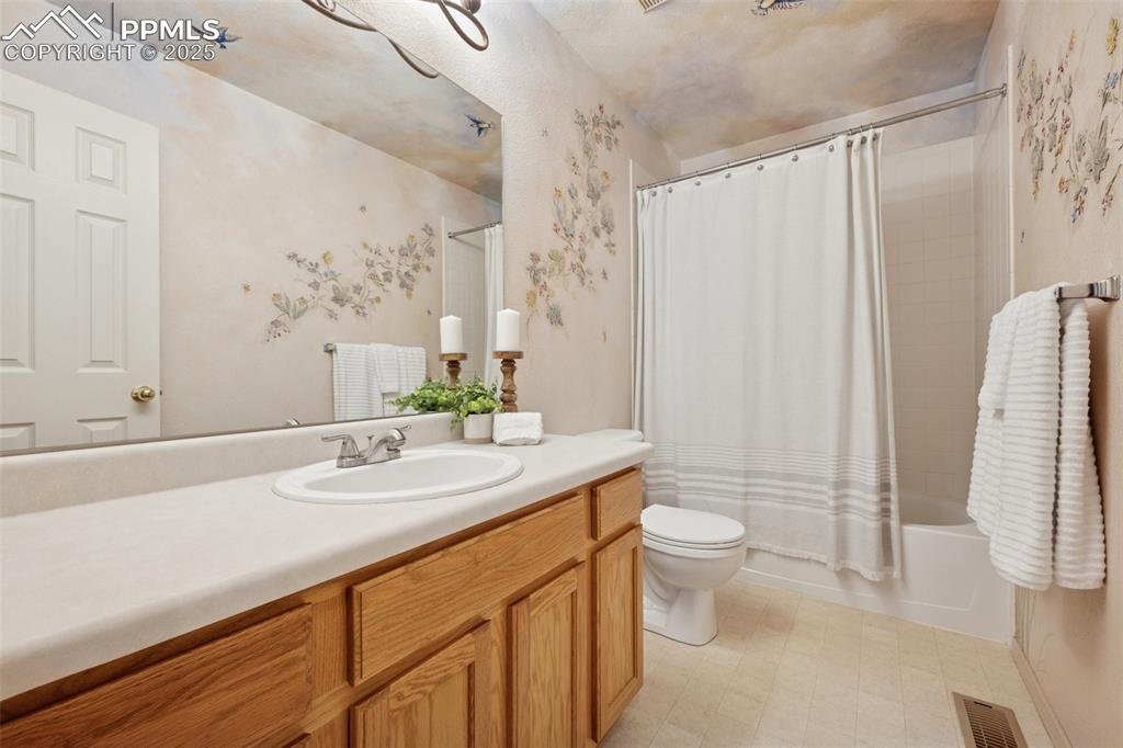 Image 13 of 27: Full bathroom featuring shower / bathtub combination with curtain and vanit