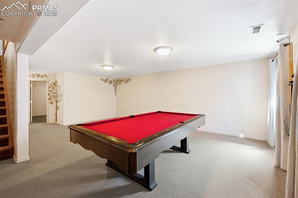 Image 16 of 27: Playroom with billiards table and light carpet