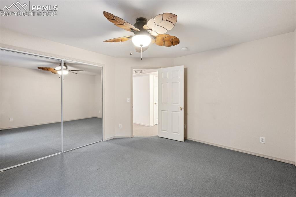 Image 20 of 27: Unfurnished bedroom with a closet, carpet floors, and a ceiling fan