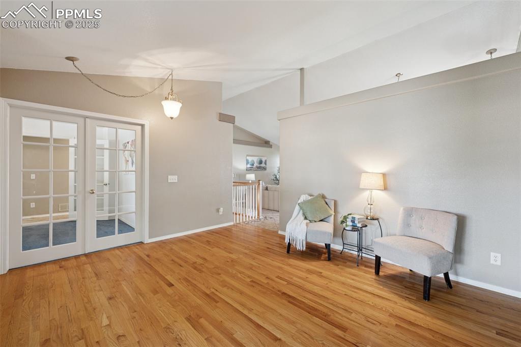 Image 3 of 27: Sitting room featuring vaulted ceiling, french doors, and light wood-type f