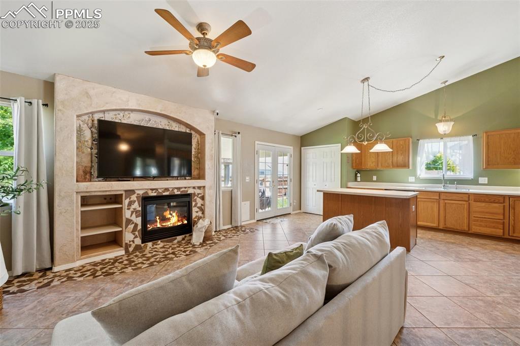 Image 5 of 27: Living area featuring vaulted ceiling, light tile patterned flooring, healt