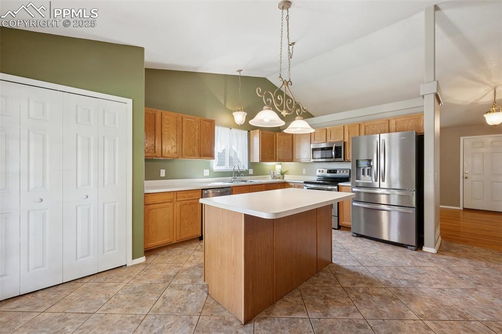 Image 7 of 27: Kitchen with appliances with stainless steel finishes, light countertops, v