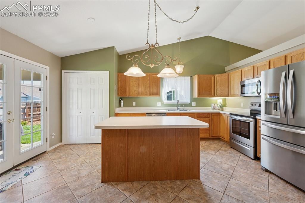 Image 8 of 27: Kitchen featuring french doors, stainless steel appliances, vaulted ceiling