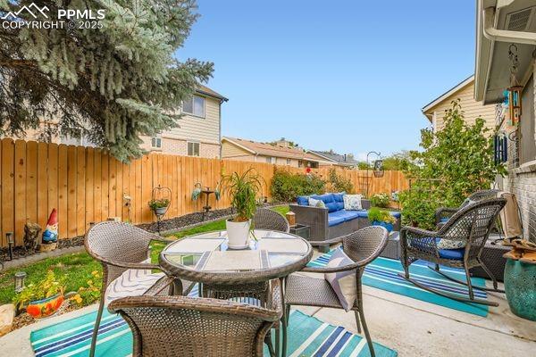 Image 13 of 15: Fenced backyard featuring a patio area, outdoor lounge area, and outdoor di