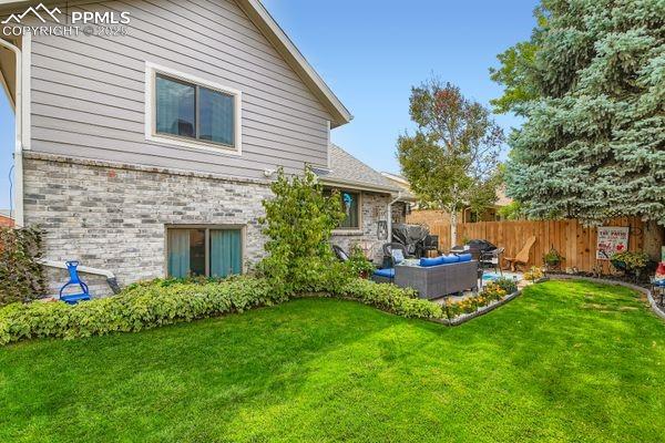 Image 14 of 15: Rear view of property featuring an outdoor living space and brick siding