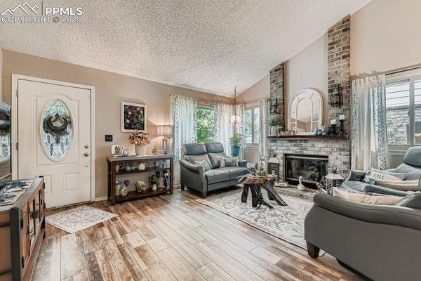 Image 2 of 15: Living area with a textured ceiling, plenty of natural light, high vaulted