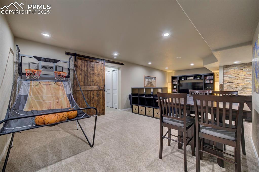 Image 37 of 46: Dining space featuring recessed lighting, a barn door, and carpet flooring