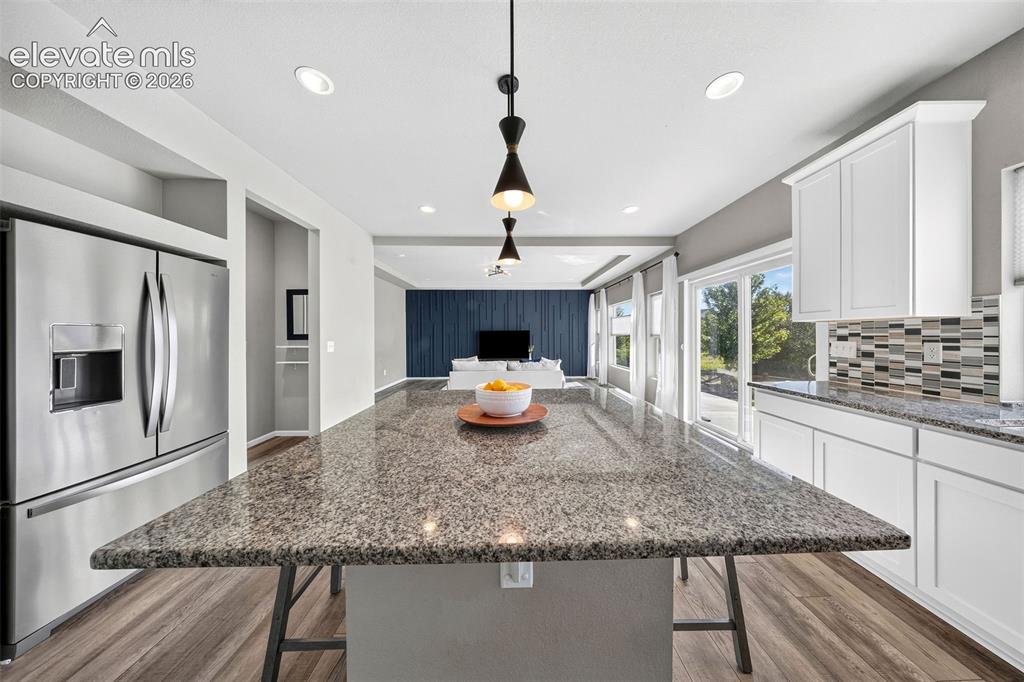 Image 13 of 48: The island is huge and can handle all. your prep or seat a crowd. Granite c