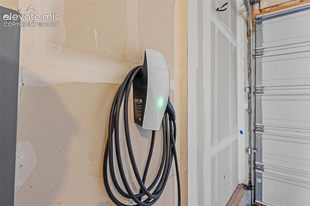 Image 16 of 48: The clean and spacious two-car garage includes a Tesla charger to keep you 