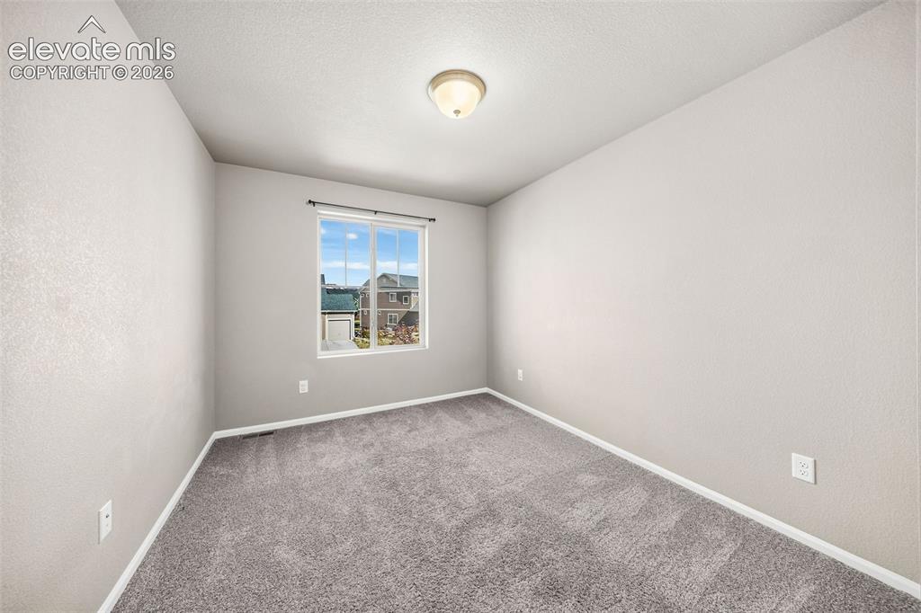 Image 26 of 48: This is the second of three bedrooms on the upper level. It features a reac