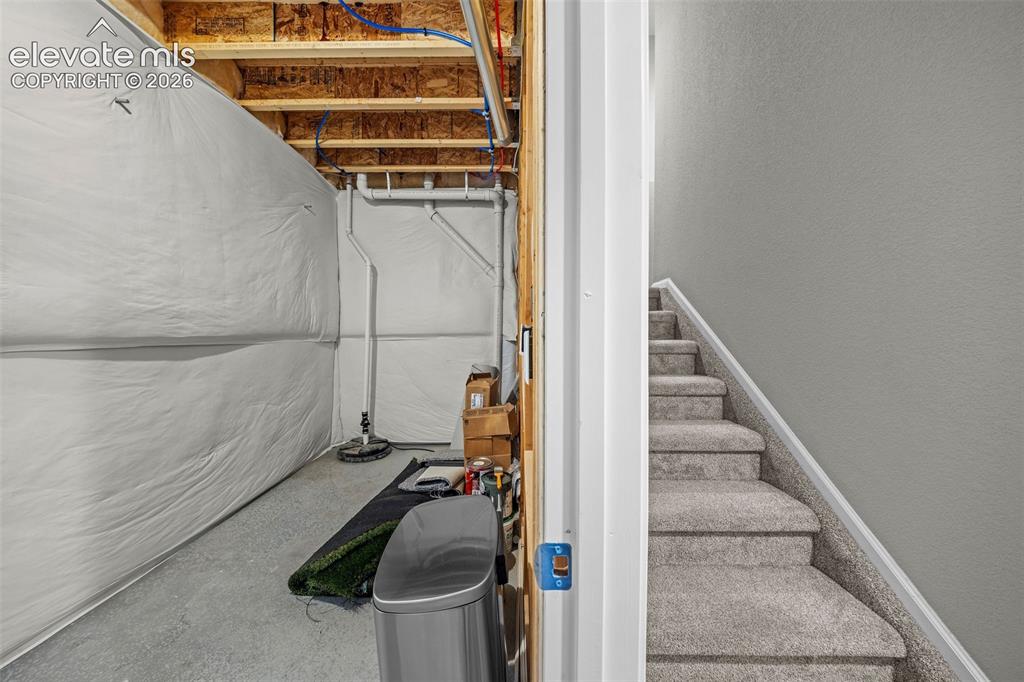 Image 35 of 48: This storage area under the stairs is the perfect spot to hide all the thin