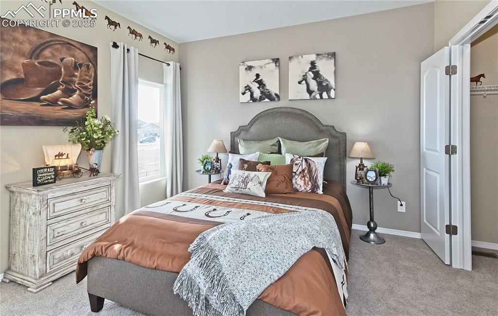 Image 19 of 30: Bedroom with light colored carpet and baseboards