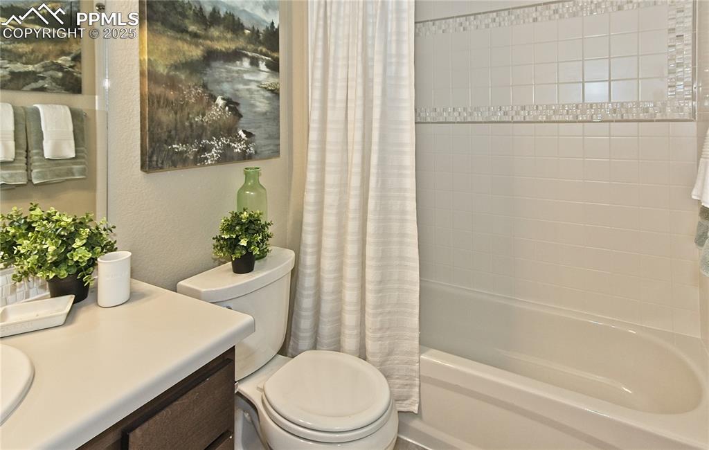 Image 30 of 30: Full bath featuring shower / tub combo with curtain, vanity, and a textured