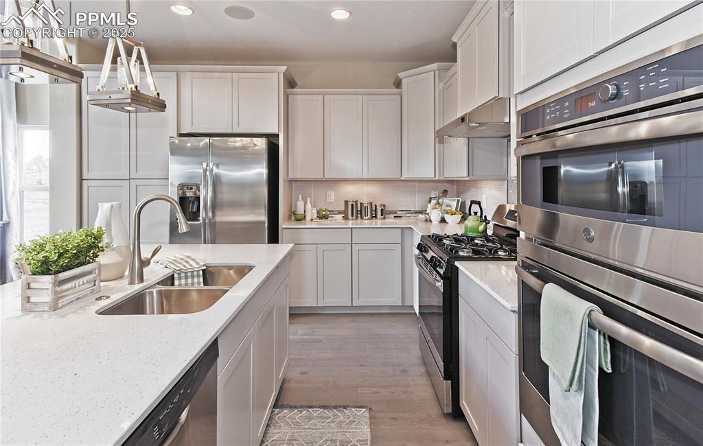 Image 8 of 30: Kitchen featuring appliances with stainless steel finishes, backsplash, dec