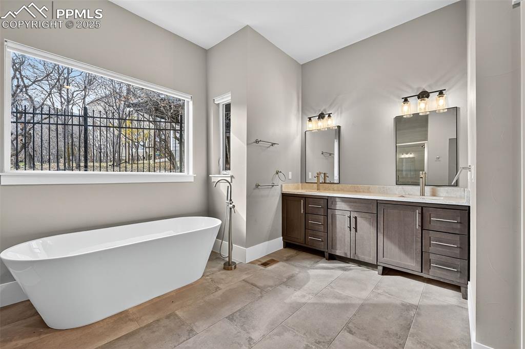 Image 18 of 50: Full bath featuring a freestanding bath, vanity, and a stall shower