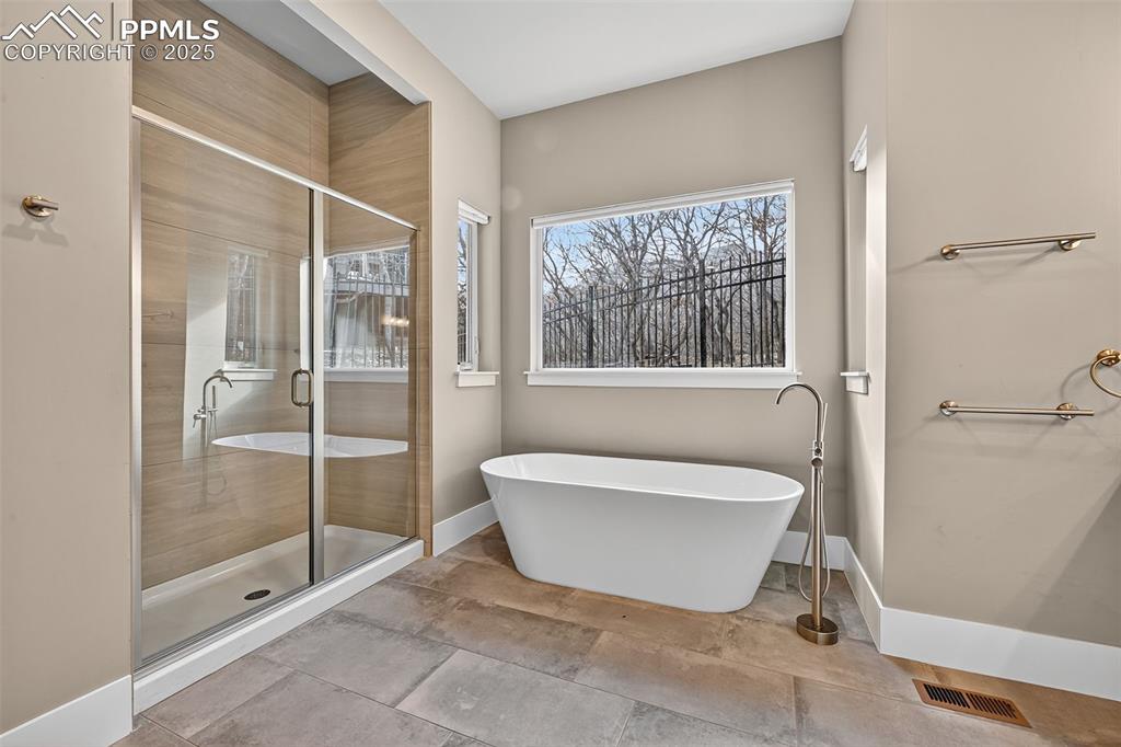 Image 19 of 50: Bathroom featuring a stall shower and a freestanding bath