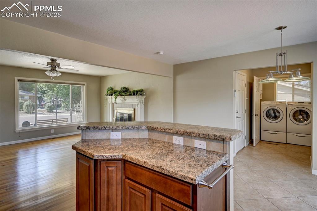 Image 13 of 33: Kitchen with washing machine and dryer, a center island, ceiling fan, penda