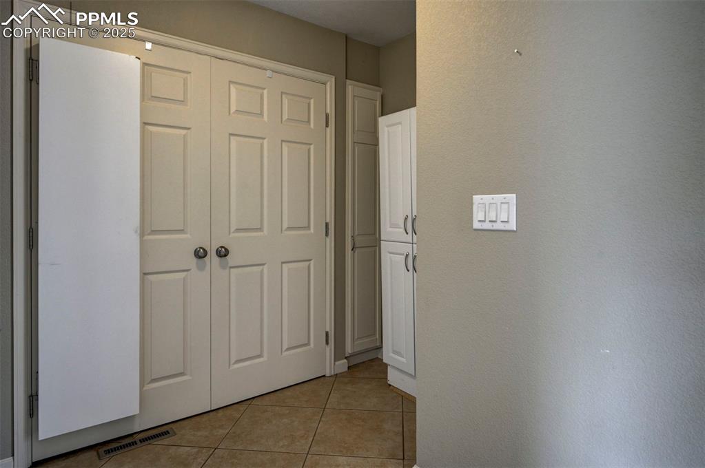 Image 16 of 33: Hall with light tile patterned floors