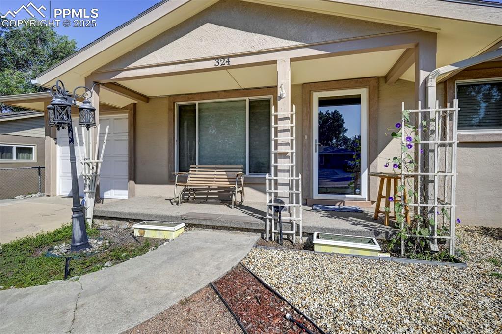 Image 2 of 33: Front covered porch, stucco siding.
