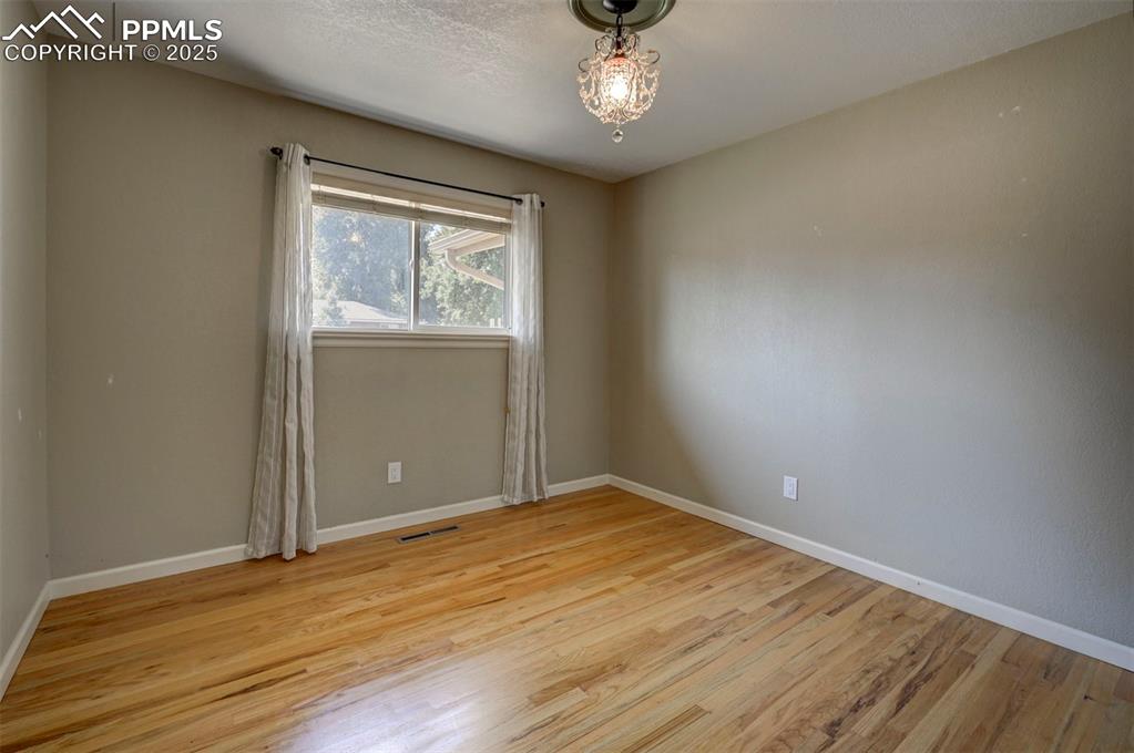 Image 22 of 33: Empty room featuring light wood-type flooring and a textured ceiling